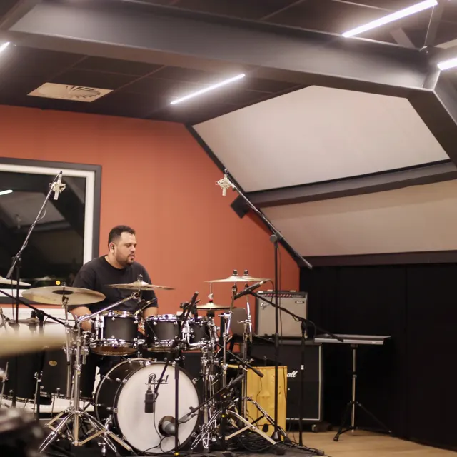 Anthony achter het drumstel in de studio aan de Zwarteweg, met oranje wand en schuin dak